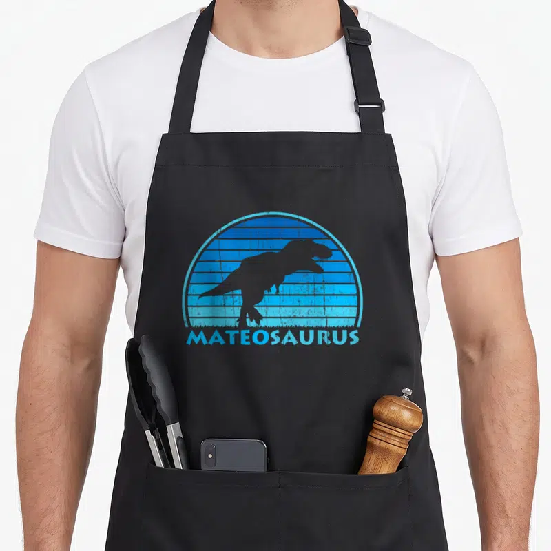 Tablier de cuisine noir avec silhouette de dinosaure et texte Mateosaurus en bleu rétro.