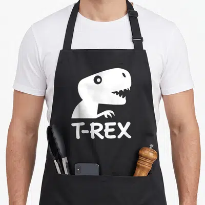 Tablier de cuisine noir avec silhouette blanche de tête de T-Rex et texte T-REX en bas.