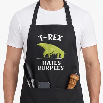 Tablier de cuisine noir avec un T-Rex vert épuisé et le texte T-Rex Hates Burpees en blanc.