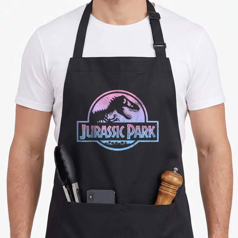 Tablier de cuisine noir avec logo Jurassic Park en dégradé rose et bleu style vintage
