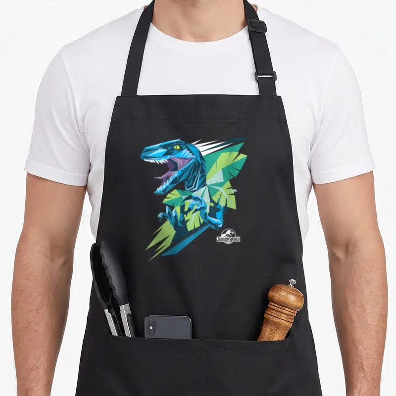 Tablier de cuisine noir avec illustration géométrique d'un raptor bleu et vert aux couleurs vives.