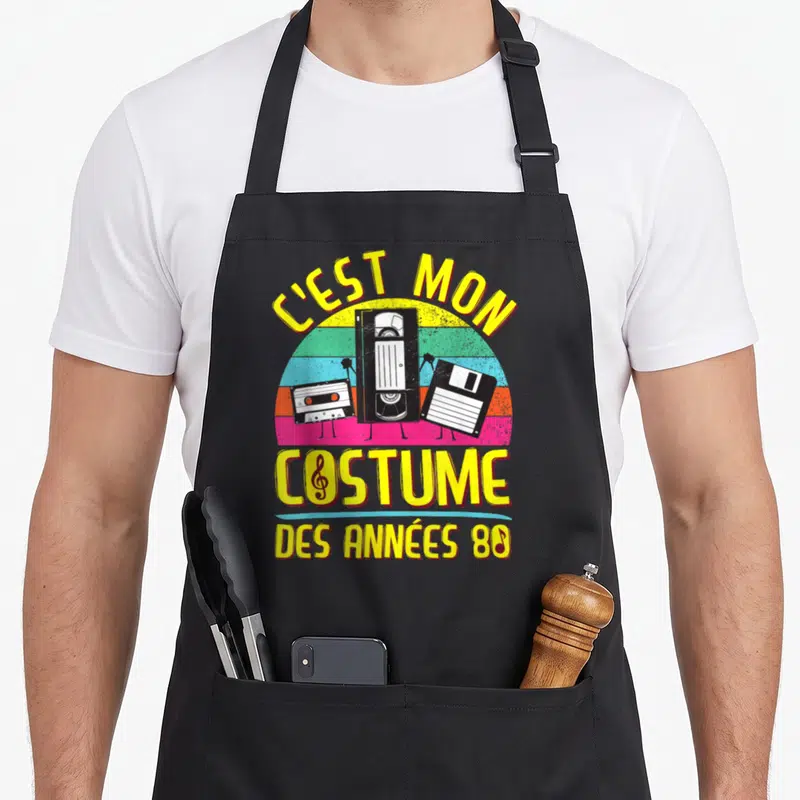 Tablier de cuisine noir avec illustration de cassettes et texte C'est mon costume des années 80 en jaune vif.
