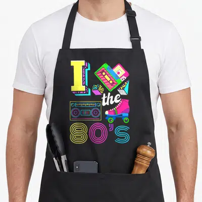 Tablier de cuisine noir avec illustration colorée I the 80's, cassette, boombox et patins à roulettes roses.