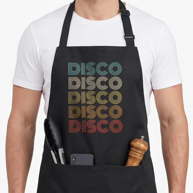 Tablier de cuisine noir avec le mot Disco imprimé en lettres rayées multicolores style années soixante-dix.