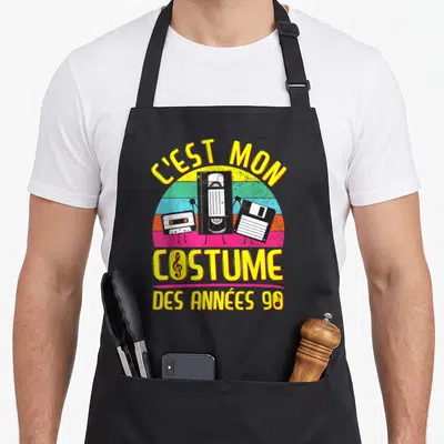 Tablier de cuisine noir avec illustration de cassettes, cassette VHS et disquette sur fond arc-en-ciel coloré.