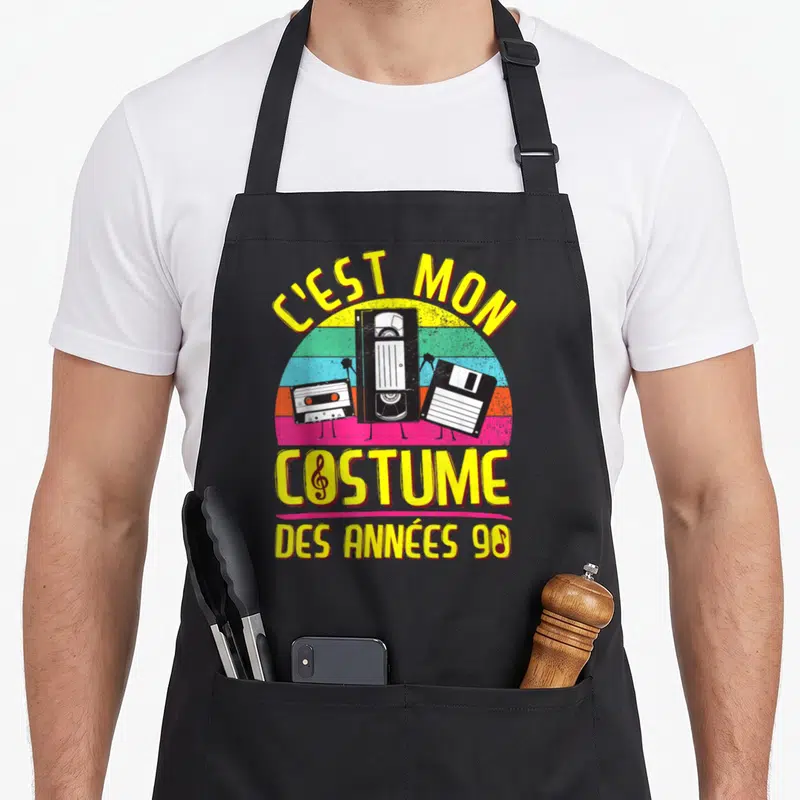 Tablier de cuisine noir avec illustration de cassettes, cassette VHS et disquette sur fond arc-en-ciel coloré.