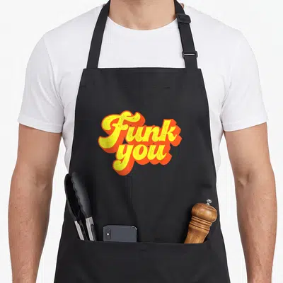 Tablier de cuisine noir avec linscription stylisée Funk You en lettres jaunes et orange à effet rétro.