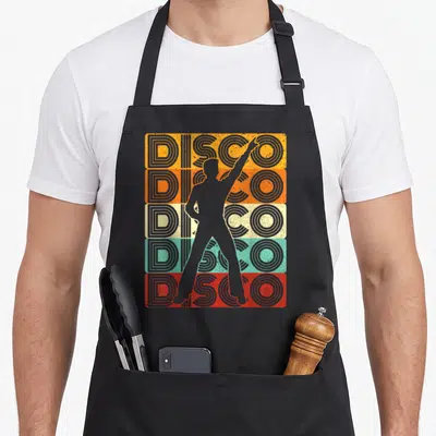 Tablier de cuisine noir avec silhouette d'homme dansant devant cinq bandes colorées portant le mot DISCO en typographie vintage.
