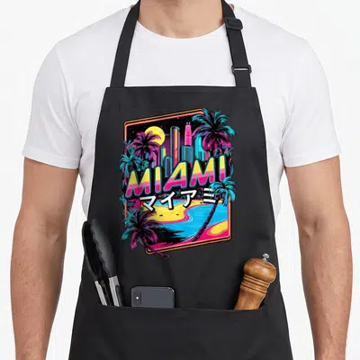 Tablier de cuisine noir avec illustration colorée de Miami, palmiers turquoise et lettrage jaune rose sur fond nuit étoilé.