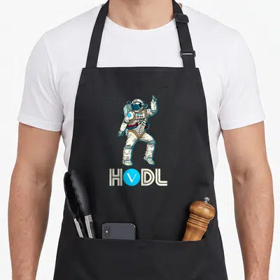 Tablier de cuisine noir avec un astronaute blanc dansant et le texte HODL VET en bleu et beige.