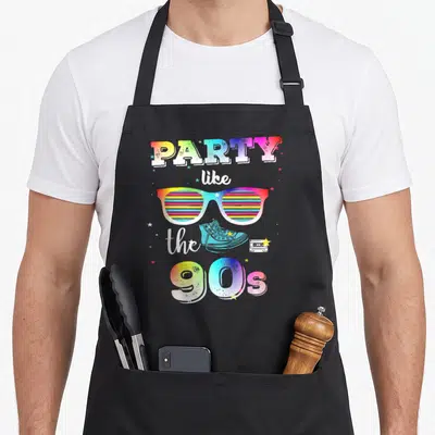 Tablier de cuisine noir avec inscription Party like the 90s, lunettes colorées et sneakers vintage.