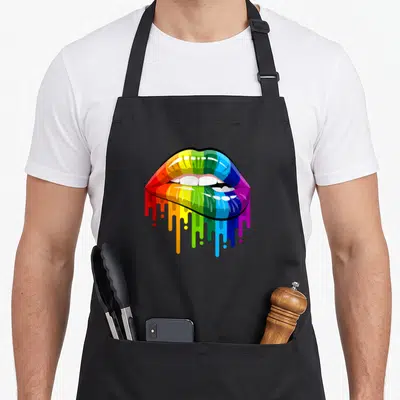Tablier de cuisine noir avec lèvres graphiques colorées en arc-en-ciel qui dégoulinent, style années 80.