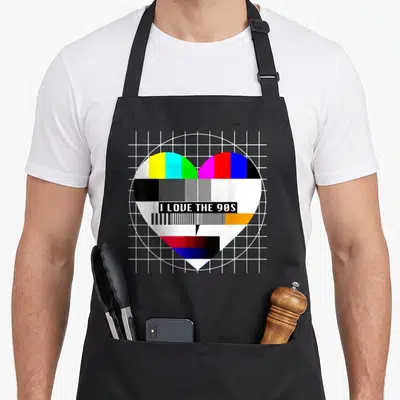 Tablier de cuisine noir avec un cœur aux bandes de test couleur et l'inscription I Love The 90s au centre.