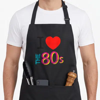 Tablier de cuisine noir avec un cœur rouge et le texte I love the 80s en lettres colorées.