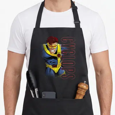 Tablier de cuisine noir avec illustration rétro de Cyclops et son nom en lettres roses verticales.