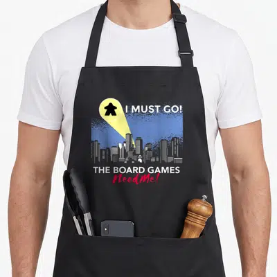 Tablier de cuisine noir avec un meeple sous projecteur et une skyline urbaine en arrière-plan.