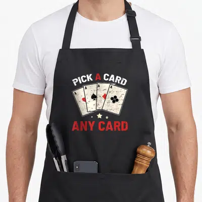 Tablier de cuisine noir avec illustration de quatre as et texte Pick a card any card en rouge et blanc.