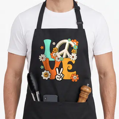 Tablier de cuisine noir avec motif Love, signe de paix, fleurs orange et main victorieuse vintage années 60