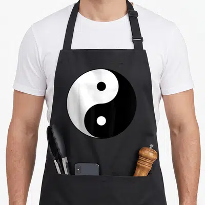 Tablier de cuisine noir avec grand symbole Yin Yang blanc et noir centré sur le devant.