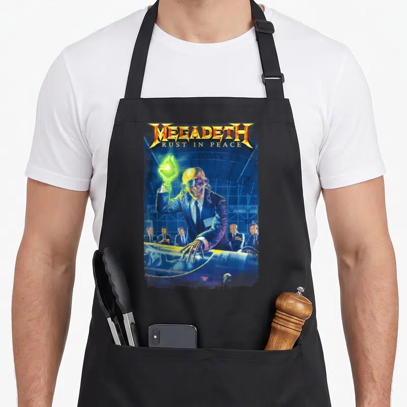 Tablier de cuisine noir avec un crâne en costume tenant une lumière verte et le texte Megadeth Rust in Peace.