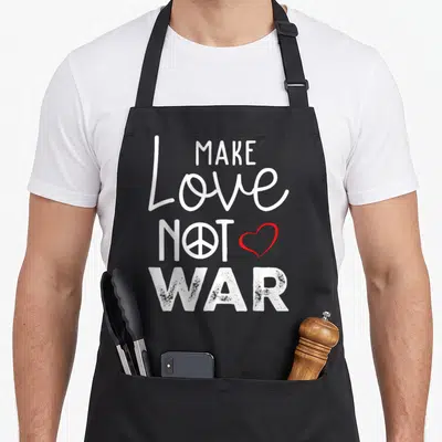 Tablier de cuisine noir avec inscription Make Love Not War et symboles de paix et cœur rouge.