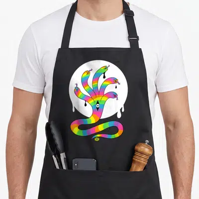 Tablier de cuisine noir avec illustration serpent arc-en-ciel à plusieurs têtes et œil au centre sur fond blanc circulaire.