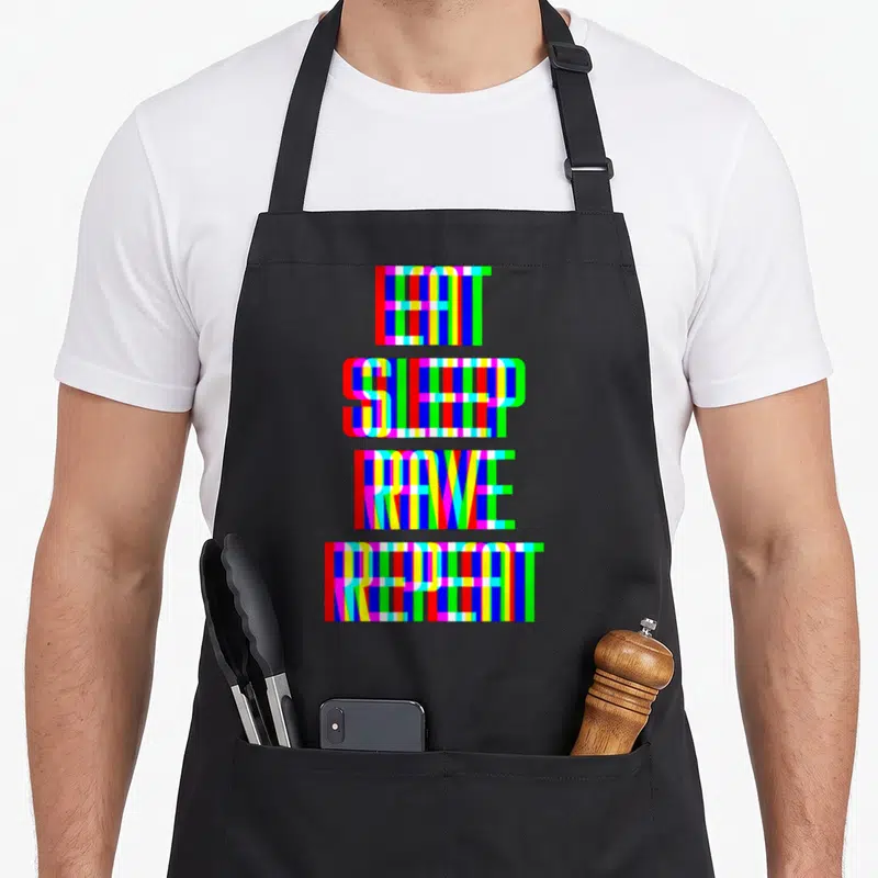Tablier de cuisine noir avec l'inscription Eat Sleep Rave Repeat en lettres multicolores à effet numérique.