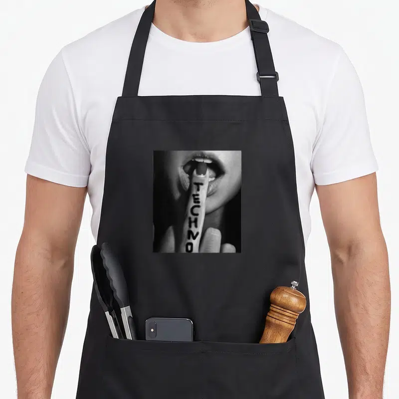 Tablier de cuisine noir avec illustration monochrome d'une bouche et un index portant le mot TECHNO en lettres noires verticales.