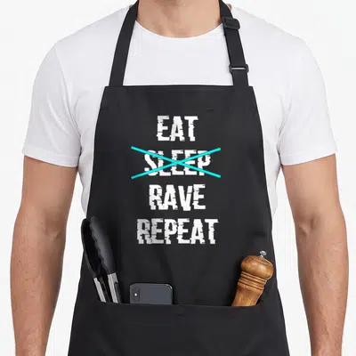Tablier de cuisine noir avec le texte blanc Eat Sleep Rave Repeat et une croix cyan sur le mot Sleep.
