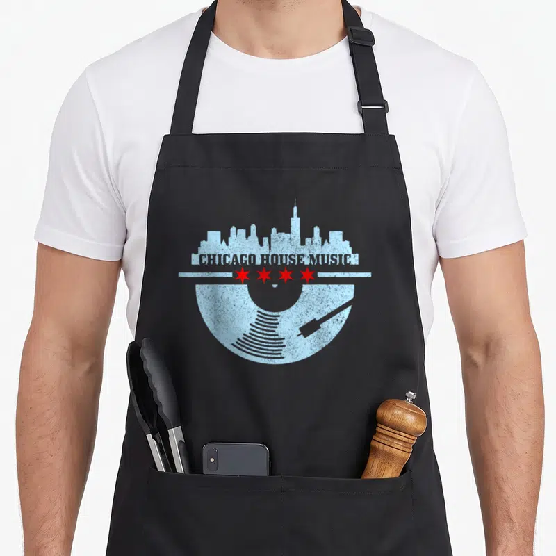 Tablier de cuisine noir avec un motif circulaire bleu clair représentant un vinyle, une skyline et le texte Chicago House Music surmonté de quatre étoiles rouges.