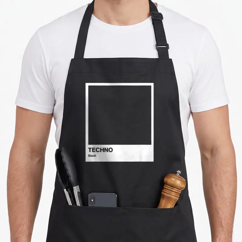 Tablier de cuisine noir avec motif graphique blanc rectangulaire affichant le mot TECHNO en bas à gauche.