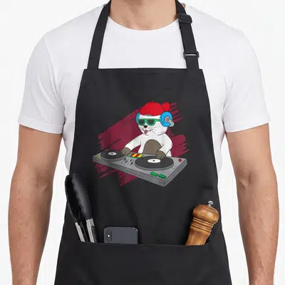 Tablier de cuisine noir avec illustration d'un chat blanc DJ portant casque bleu et bonnet rouge devant une platine tournante.