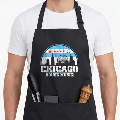 Tablier de cuisine noir avec illustration circulaire du drapeau de Chicago et skyline gris sur fond bleu et blanc.