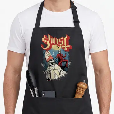 Tablier de cuisine noir avec illustration d'un pape squelettique et d'un homme en rouge sous une lune jaune.