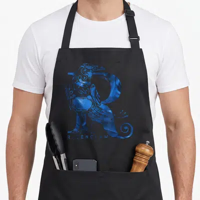 Tablier de cuisine noir avec un corbeau bleu orné d'une lettre R et le texte RAVENCLAW en bas.