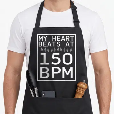 Tablier de cuisine noir avec l'inscription blanche My Heart Beats At 150 BPM et une ligne d'électrocardiogramme.