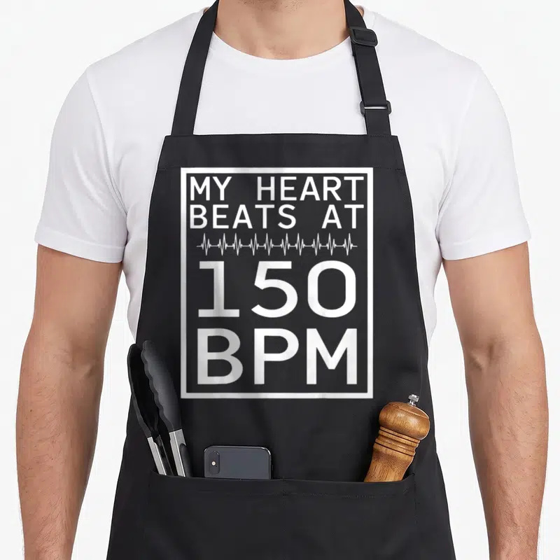 Tablier de cuisine noir avec l'inscription blanche My Heart Beats At 150 BPM et une ligne d'électrocardiogramme.