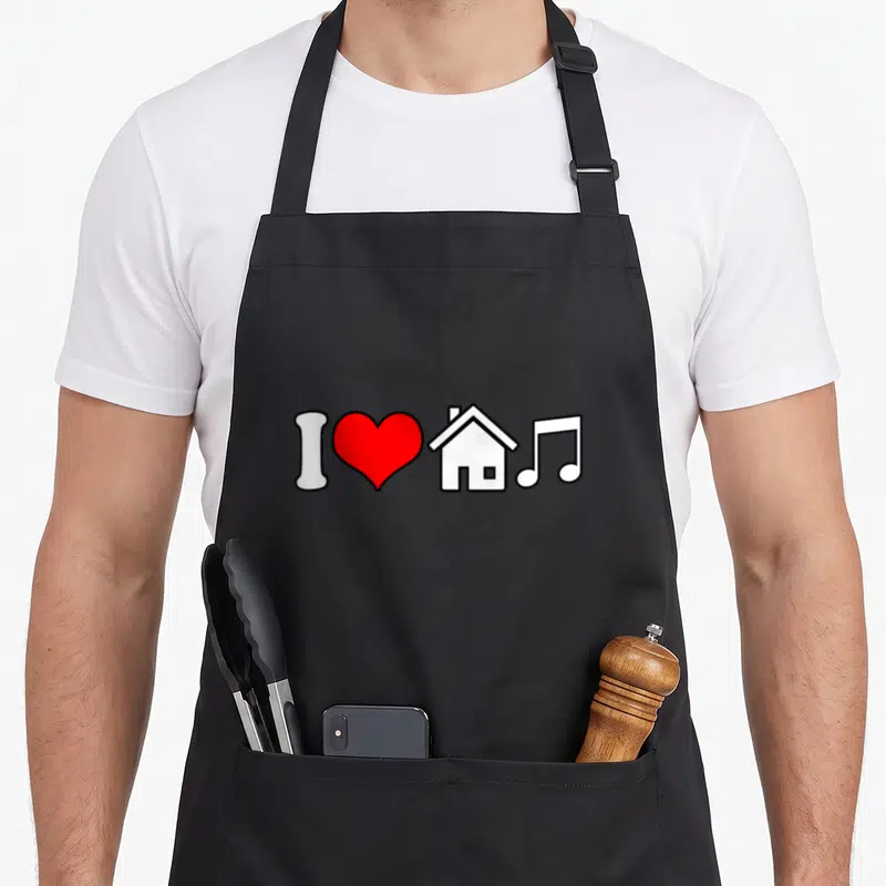 Tablier de cuisine noir avec un cœur rouge, une maison blanche et une note de musique stylisée.