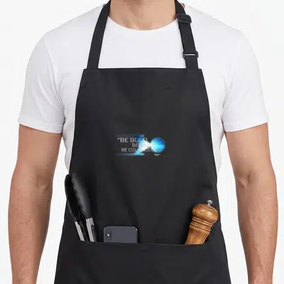 Tablier de cuisine noir avec le texte Be Bold Be Brave Be Courageous et une sphère lumineuse bleue sur fond uni.
