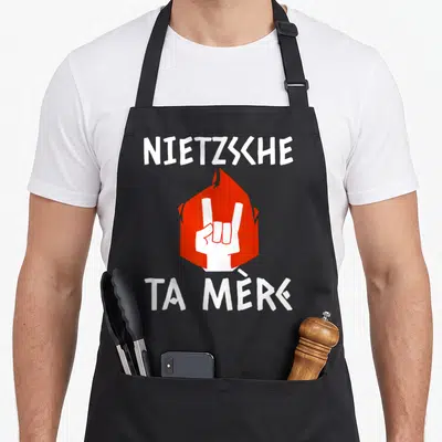 Tablier de cuisine noir avec inscription Nietzsche ta mère et main blanche sur fond rouge en forme de flamme.