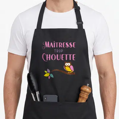 Tablier de cuisine noir avec inscription Maîtresse trop chouette et hibou sur branche fleurie.