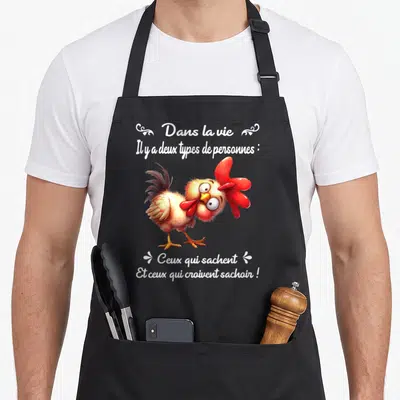 Tablier de cuisine noir avec illustration d'un poulet et texte blanc sur fond gris.