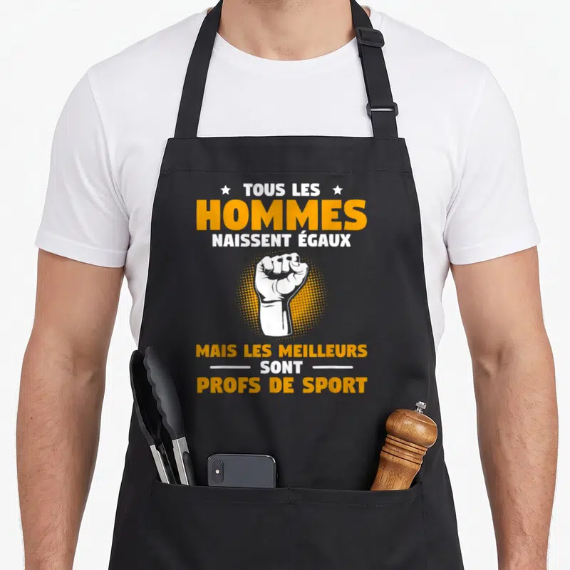 Tablier de cuisine noir avec inscription Tous les hommes naissent égaux mais les meilleurs sont profs de sport et un poing levé.