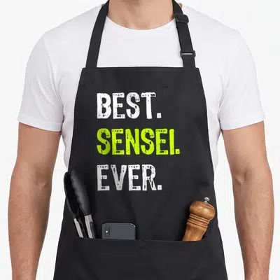 Tablier de cuisine noir avec l'inscription Best Sensei Ever en typographie verte et blanche.