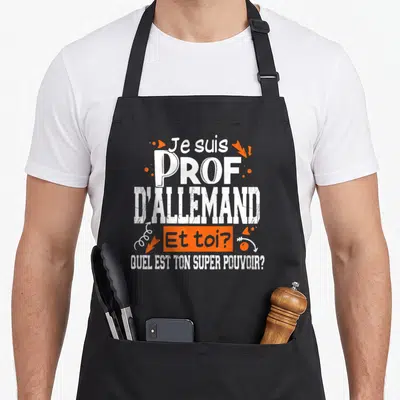 Tablier de cuisine noir avec inscription Je suis Prof d'Allemand Et toi Quel est ton super pouvoir en blanc et orange.