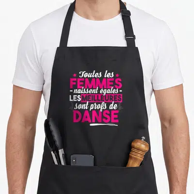 Tablier de cuisine noir avec inscription rose et blanche toutes les femmes naissent égales les meilleures sont profs de danse