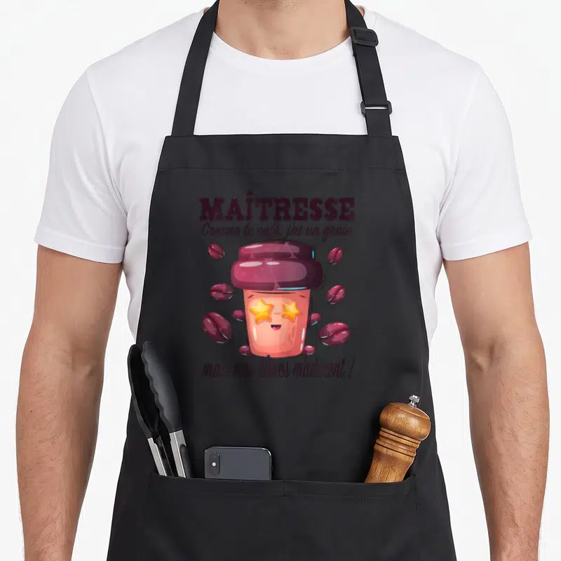 Tablier de cuisine noir avec illustration gobelet café étoiles et texte Maîtresse Comme le café j'ai un grain mais mes élèves m'adorent