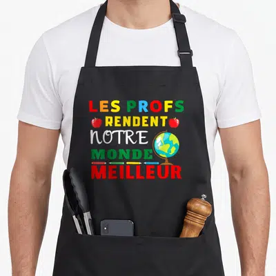 Tablier de cuisine noir avec les mots Les profs rendent notre monde meilleur et des illustrations d'école.