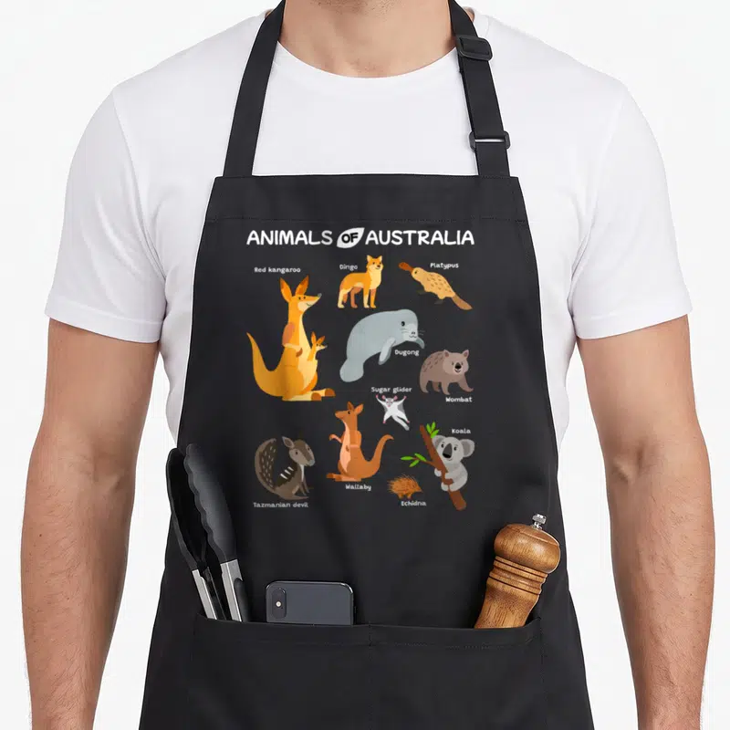 Tablier de cuisine noir avec une illustration colorée présentant divers animaux typiques d'Australie comme le kangourou et le koala.