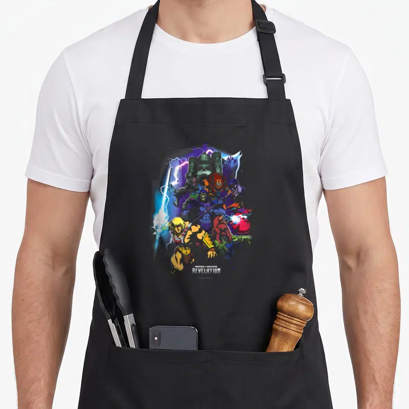 Tablier de cuisine noir avec illustration colorée de He-Man, Skeletor et Castle Grayskull en style graffiti.